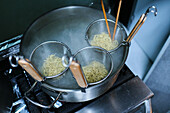 Stock photo of casserole with boiling water cooking noodles.