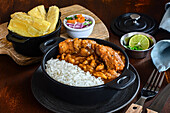 Delicious dish of rice with stew of dehydrated potatoes and meat slices against cooked cassava and vegetable salad on cutting board