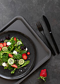 Self-service restaurant with a plate with a summery strawberry and cucumber salad on a tray