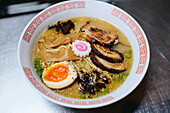 Stockfoto von leckerer Ramen-Suppe mit gekochtem Ei und Pilzen in einem japanischen Restaurant