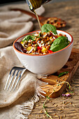 From above appetizing colorful cut vegetable mix with spinach lentils and rice on wooden background