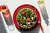 From above tuna salad with onion and tomatoes served on red plates on white background