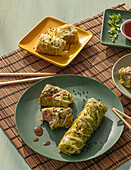 Cabbage spring rolls served on bamboo place mat near chopsticks