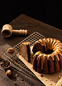 From above coffee walnut bundt cake placed on baking net on dark rustic wooden table in kitchen