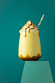 Salted caramel frappe coffee served on glass at colorful blue background