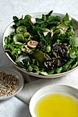 Top view of fresh healthy vegetable salad in bowl served on table with olive oil and sunflower seeds