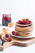 Himbeeren Pfannkuchen auf einem rustikalen Holz auf einem weißen Hintergrund mit unscharfem Hintergrund