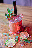 From above of copper mug with Moscow Mule cocktail made with vodka spicy ginger beer and lime juice topped with mint leaves