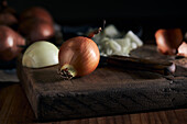 Rustic bowl with pieces of cut onion placed near knife on lumber table in kitchen