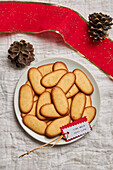 Top view of pile of delicious Christmas cookies placed on plate on tablecloth for holiday celebration