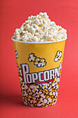 Bowl full of popcorn on a red background