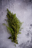 Top view of bundle of aromatic green dill with thin stems on rugged surface