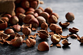 Bunch of ripe hazelnuts and shells scattered on marble table and burlap bag