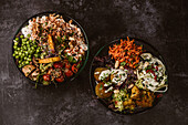 Appetizing organic vegetarian dishes with assorted vegetables on rustic dark table