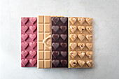 From above of delicious colorful chocolate bars placed in row on white background