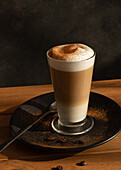 Glass of fresh hot aromatic latte coffee served on table