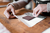Anonymous person placing handmade chocolate bar on piece of paper while working in confectionery