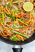 From above tasty stir fry rice noodles with vegetables served in frying pan