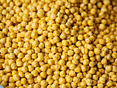 Full frame background of peeled golden chickpea arranged on surface in market stall