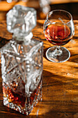 Old fashioned cognac glass on wooden table with natural light