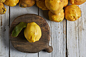 Top view of fresh whole sour yellow lemon on white wooden background