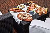 Table set up on a terrace with various delicious appetizers such as serrano ham, skewered pickled , nuts, etc