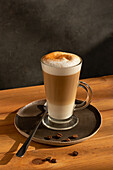 Glass of fresh hot aromatic latte coffee served on table
