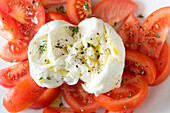 From above closeup of ripe tomato slices and mozzarella cheese served on white plate