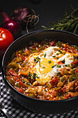 High angle of appetizing traditional Spanish dish made of egg and assorted vegetables and served in bowl on table