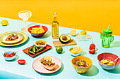 From above assorted traditional Mexican dishes and drinks placed on blue table near yellow wall