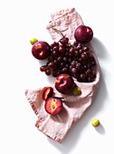 Fresh plums and grapes on white background. Purple food. Harvest concept.