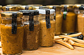 Closeup of many closed glass bottles with fresh yellow homemade blended vegetable mix inside placed on table