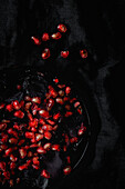 Frischer und roter Granatapfel auf dunklem Hintergrund. Herbstsaison Obst. Top flay; Ansicht von oben