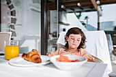 Selective focus of cute dark haired girl sleeping at table with food on plates in light cafeteria