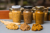 Closeup of many closed glass bottles with fresh yellow homemade blended vegetable mix inside placed on table