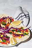 Homemade Mexican Tacos with fresh vegetables and chicken with strong light on white background. Healthy food. Typical Mexican