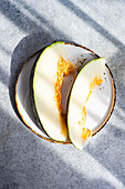 Top view of slices of ripe melon on ceramic plate