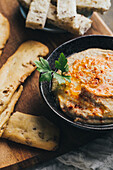 Leckerer Hummus mit Paprika, Olivenöl und etwas Brot zum Dippen