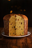 Sliced fresh baked artisan Christmas panettone cake under warm light against bokeh background