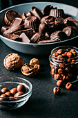 Various handmade chocolates with nuts arranged placed on black table