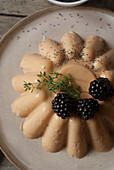 Closeup from above shot of tender peach panna cotta with blackberry and poppy seeds
