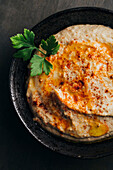 Leckerer Hummus mit Paprika, Olivenöl und etwas Brot zum Dippen