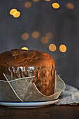Uncut fresh baked artisan Christmas panettone cake under warm light against bokeh background