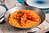 High angle of palatable rice with red prawns served in plate on table in Asian restaurant
