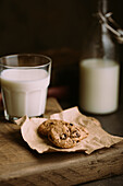 Homemade chocolate chips cookies with a glass of milk and straw