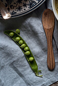 Closeup of served bowls with green pea and coconut cream soup on table