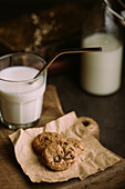 Homemade chocolate chips cookies with a glass of milk and straw