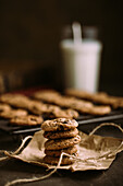 Homemade chocolate chips cookies on cooling rack with a glass of milk