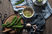 Nahaufnahme von servierten Schalen mit grüner Erbsen- und Kokosnusscremesuppe auf dem Tisch