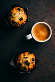 Schokoladenmuffins und Kaffeetasse auf dunklem Hintergrund